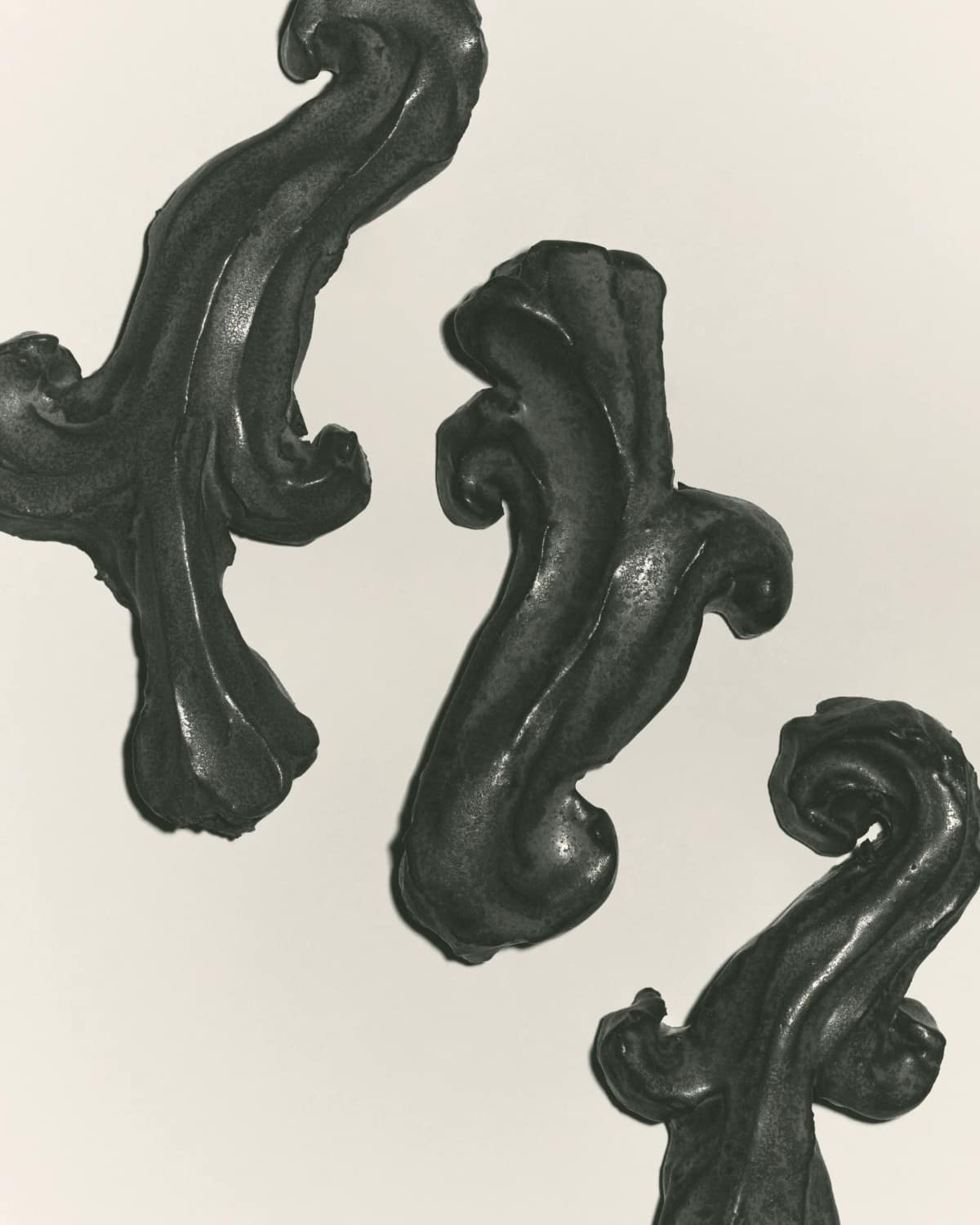 Three dark glazed acanthus reliefs floating on a pale ground